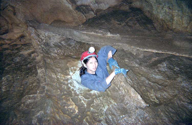 Angie wiggling out of the Womb at Cal Cavern